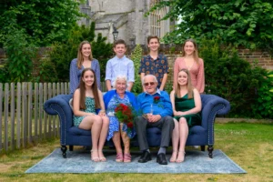 A group photograph on a sofa placed in the gardens of a hotel in Christchurch Dorset for the 70th Wedding Anniversary shoot. 70 years married, amazing. Devon Photographer - Robb Webb