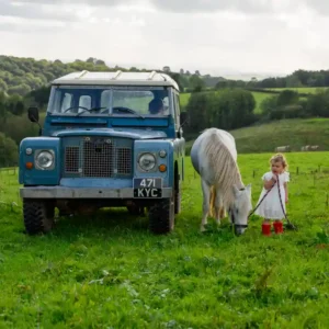 An environmental photo shoot with 18month old Binky sat on the bonnet of a vintage Land Rover and her pony patience stood beside her. Devon Photographer - Robb Webb